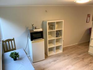 a living room with a tv and a white cabinet at Green wonder in Friedrichsdorf