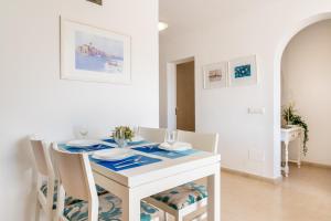 a white dining room with a white table and chairs at Apartamento Erizo de Mar in Felanitx