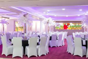 a ballroom with white tables and white chairs and a room with tables and white at Hotel Lord - Warsaw Airport in Warsaw