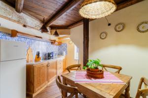 a kitchen with a wooden table and a refrigerator at Dimora Pisanelli in Specchia +15 photos