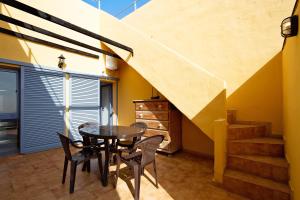 a dining room with a table and chairs and stairs at My Favorite Home in Caleta De Fuste +18 photos