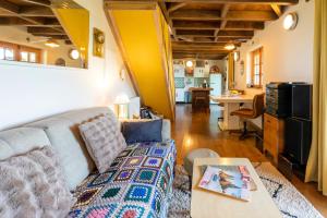 a living room with a couch and a kitchen at L'Atelier de Scarlett - Lannux in Lannux