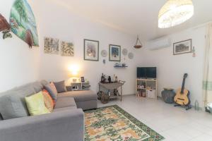 a living room with a gray couch and a tv at Rosemary House in Olbia