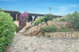 a stone walkway in front of a house with plants at Rosemary House in Olbia