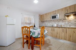 a kitchen with a table and chairs and a refrigerator at Casa Cactus in Antigua