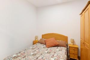 a bed with a wooden headboard and two pillows on it at Piso tazacorte in Tazacorte