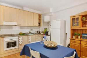 a kitchen with a blue table and a white refrigerator at Piso tazacorte in Tazacorte