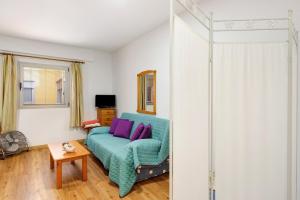 a living room with a blue couch with purple pillows at Piso tazacorte in Tazacorte