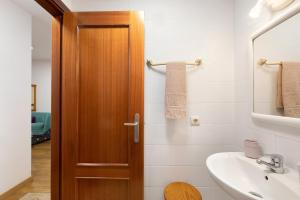 a bathroom with a wooden door and a sink at Piso tazacorte in Tazacorte