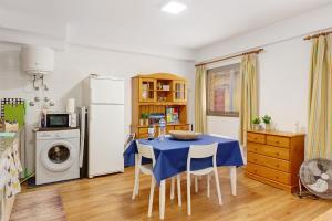 a kitchen with a table with chairs and a refrigerator at Piso tazacorte in Tazacorte +10 photos