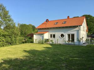 a white house with an orange roof and a yard at Wildrosenhaus in Kosel