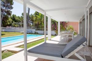 a bed on a porch next to a swimming pool at Gemelos in Alcudia