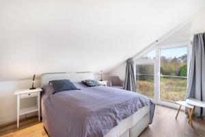 a bedroom with a bed and a large window at Wildrosenhaus in Kosel
