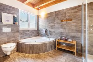 a bathroom with a tub and a toilet at Wildrosenhaus in Kosel +30 photos
