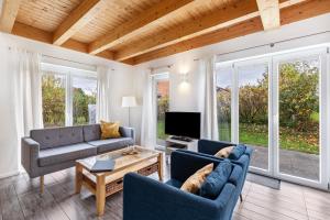 a living room with two blue couches and a tv at Wildrosenhaus in Kosel