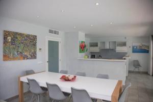 a dining room and kitchen with a white table and chairs at Gemelos in Alcudia