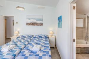 a bedroom with a blue and white bed and a bath tub at Gemelos in Alcudia +16 photos