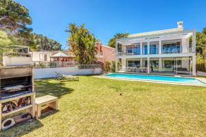 an exterior view of a house with a yard and a swimming pool at Gemelos in Alcudia