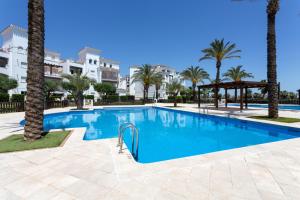 a swimming pool with palm trees and buildings at Luxury Pool and Spa - Casa Coco in Casas del Cura