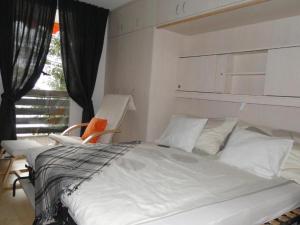 a bedroom with a white bed with a chair and a window at Alb Studio in Sankt Blasien in St. Blasien +2 photos