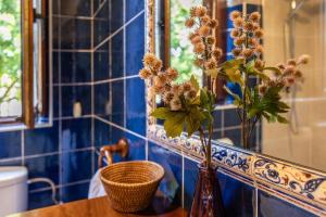 a blue tiled bathroom with a vase with flowers in it at Las Candelas - Puerto Calderón in Oreña +36 photos