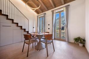 a dining room with a table and chairs and a staircase at Casa Meg in Tremosine Sul Garda
