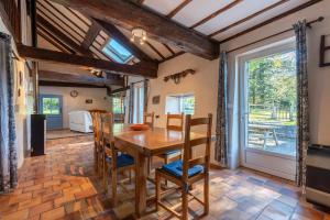 a kitchen and dining room with a wooden table and chairs at Charmante Bergerie in Castet