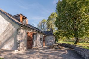 an old stone cottage with a wooden door and a picnic table at Charmante Bergerie in Castet