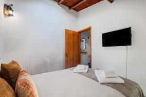 a bedroom with a large bed with a flat screen tv at Descanso Alentejano -Casa d'aldeia in Campinho