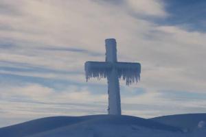 a cross covered in icicles on top of a hill at Appart 7 Laux - Balcon Sud in Les Adrets