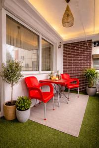 a patio with red chairs and a table at Mitrovi Apartment in Gevgelija