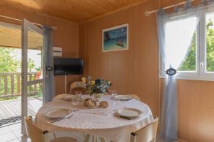 a dining room with a table with chairs and a window at Maisons Cozy - Mas Lachamp in Gravières