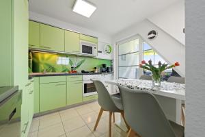 a kitchen with green cabinets and a table with chairs at Gertruds Leuchtturm Strandnah in Zingst