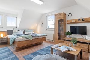 a bedroom with a large bed and a tv at Gertruds Leuchtturm Strandnah in Zingst