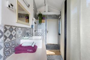 a bathroom with a white sink and a purple towel at Gîte L'ancien Préau in Avrillé-les-Ponceaux +14 photos