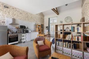 a kitchen and living room with a book shelf at Gîte L'ancien Préau in Avrillé-les-Ponceaux