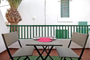 a patio table with two chairs and a red plate on it at Casa Joyne in Puerto del Carmen