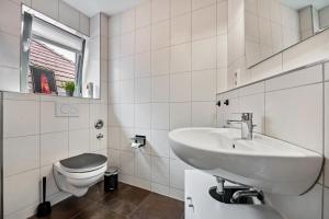 a white bathroom with a sink and a toilet at Altstadtblick Jever in Jever +23 photos