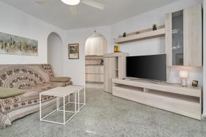 a living room with a couch and a television at Apartamento Familiar Torrox A65 in Torrox