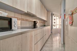 a kitchen with wooden cabinets and a microwave at Apartamento Familiar Torrox A65 in Torrox