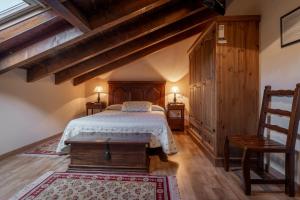 a bedroom with a bed and two tables and a chair at El Desvan Del Brigante in Lerma