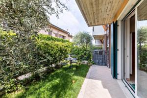 a patio with a table in the grass next to a building at Bluemoon Luminoso apt con piscina in Lazise