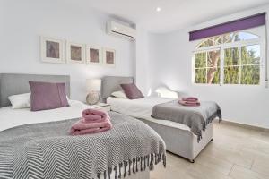 a bedroom with two beds and a window at Casa Alba in Salobreña +28 photos