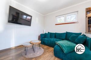 a living room with a green couch and two tables at Ferienwohnung Lahost in Lahošt