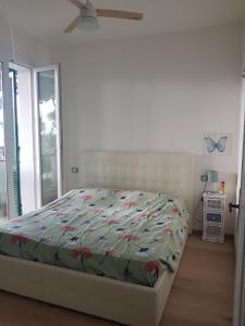 a bedroom with a bed with a floral comforter at Villa Su 3 Piani Con Giardino in Lido di Spina