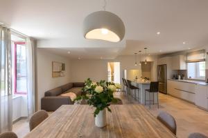 a kitchen and living room with a table and a couch at Domaine le St Georges - Piscine in Saint-Sauveur-le-Vicomte