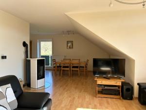 a living room with a couch and a flat screen tv at Ferienwohnung Moos-Hochsauerland in Olsberg