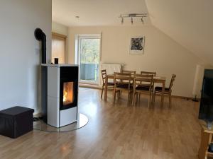 a living room with a fireplace and a table with chairs at Ferienwohnung Moos-Hochsauerland in Olsberg