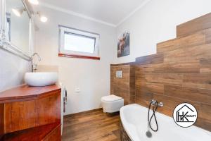 a bathroom with a tub and a sink and a toilet at Ferienwohnung Lahost in Lahošt