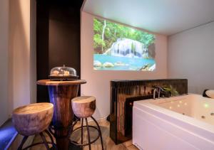 a bathroom with a tub and a waterfall painting at Suite toute équipée Jacuzzi privé in Nîmes +21 photos